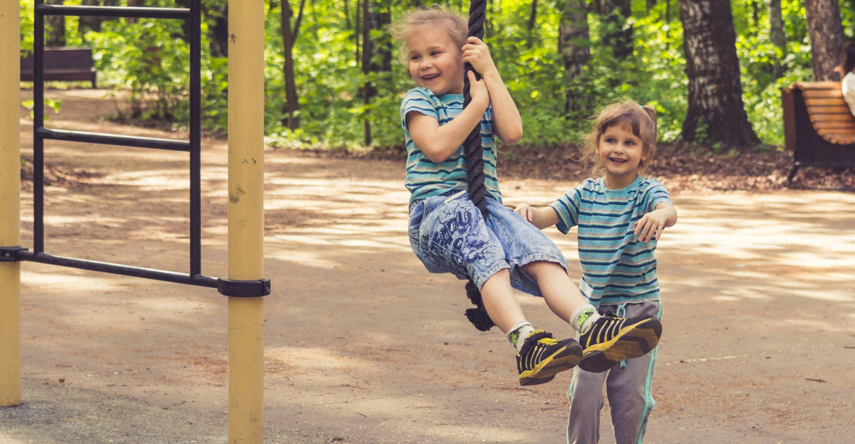 2 boys sitting on swing during daytime