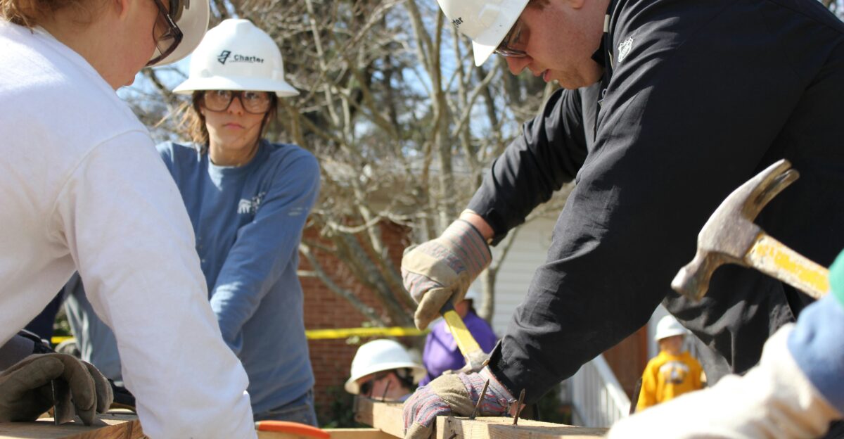 man in black jacket and white hard hat holding green plastic bottle