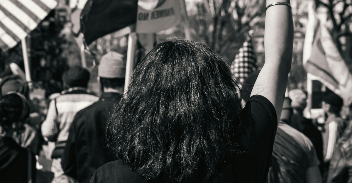 grayscale photo of woman in black shirt holding flag