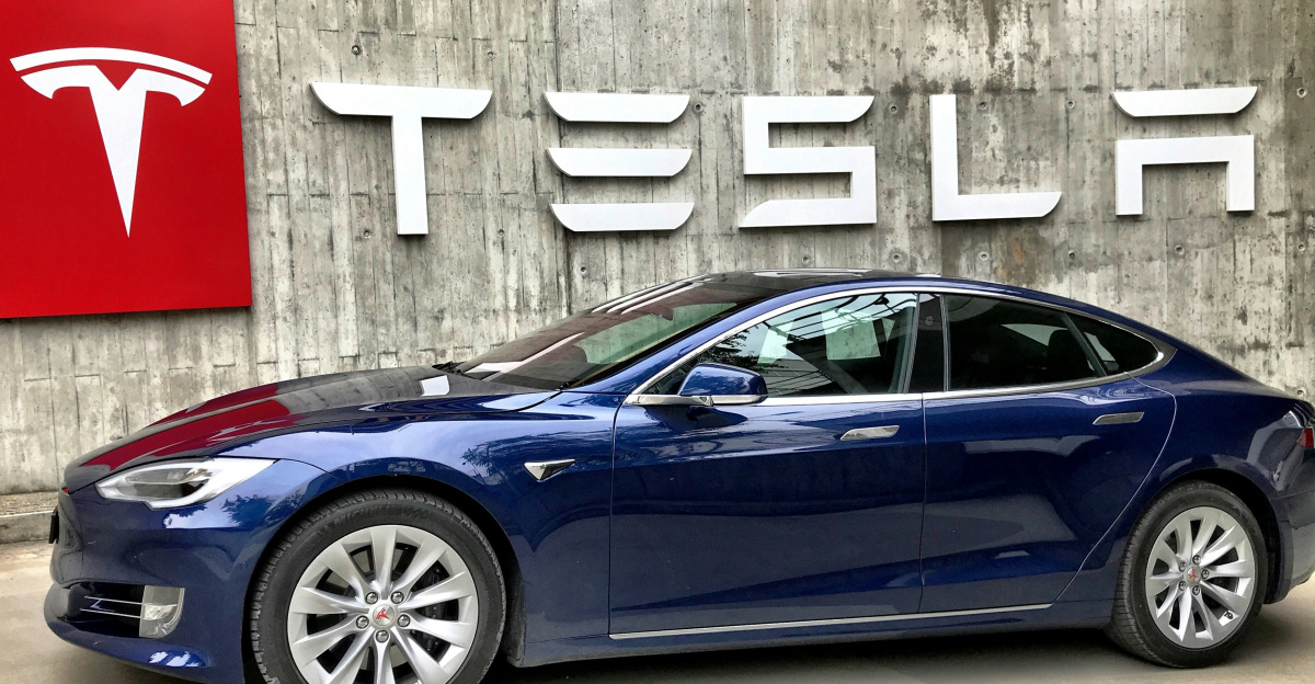 blue coupe parked beside white wall