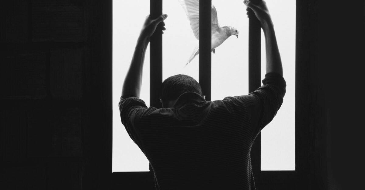 man in black long sleeve shirt raising his right hand