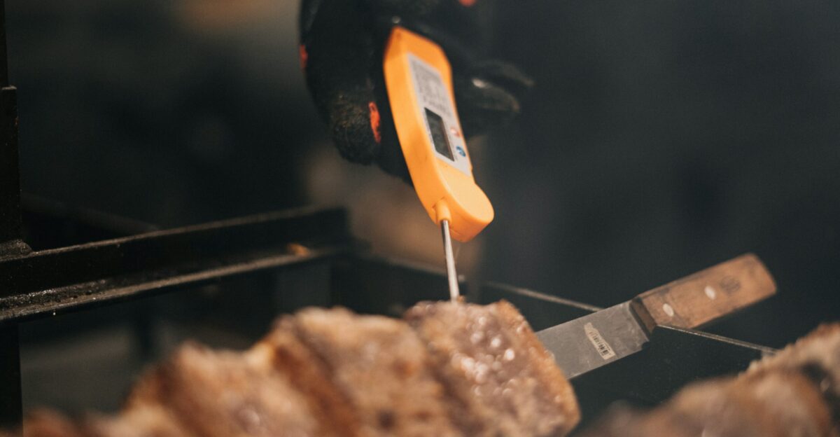 grilled meat on black and orange kettle grill