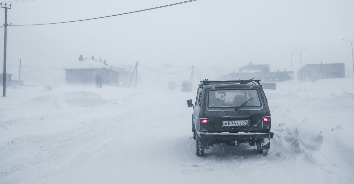 black suv on snow covered road during daytime