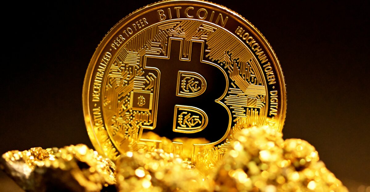 a bitcoin sitting on top of a pile of gold nuggets