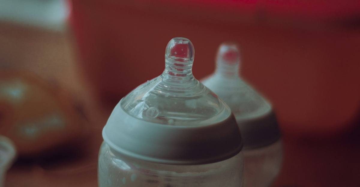 clear plastic feeding bottle on red table