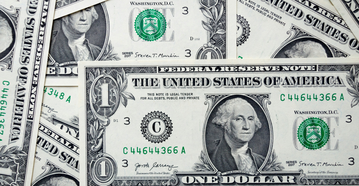 a pile of one dollar bills laying on top of each other