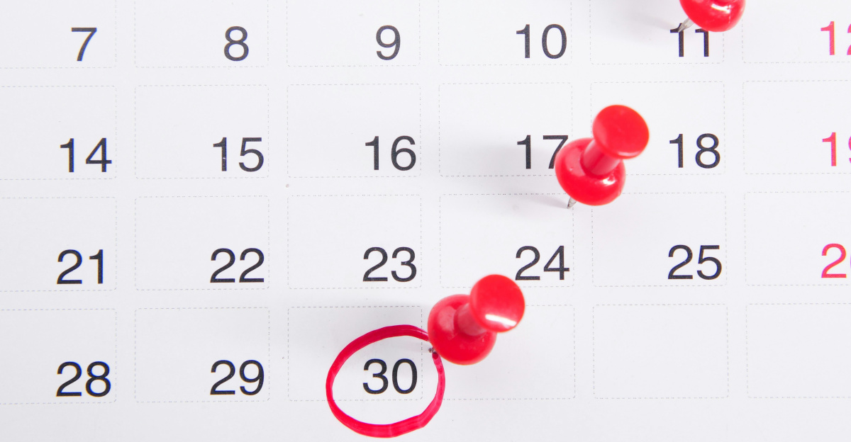 a calendar with red push buttons pinned to it