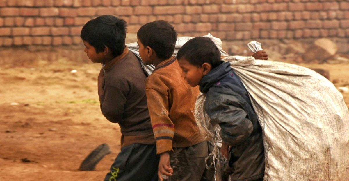 a group of young boys walking down a dirt road
