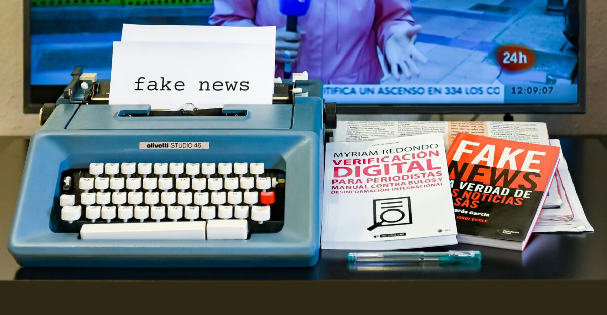 a blue typewriter sitting on top of a desk next to a tv