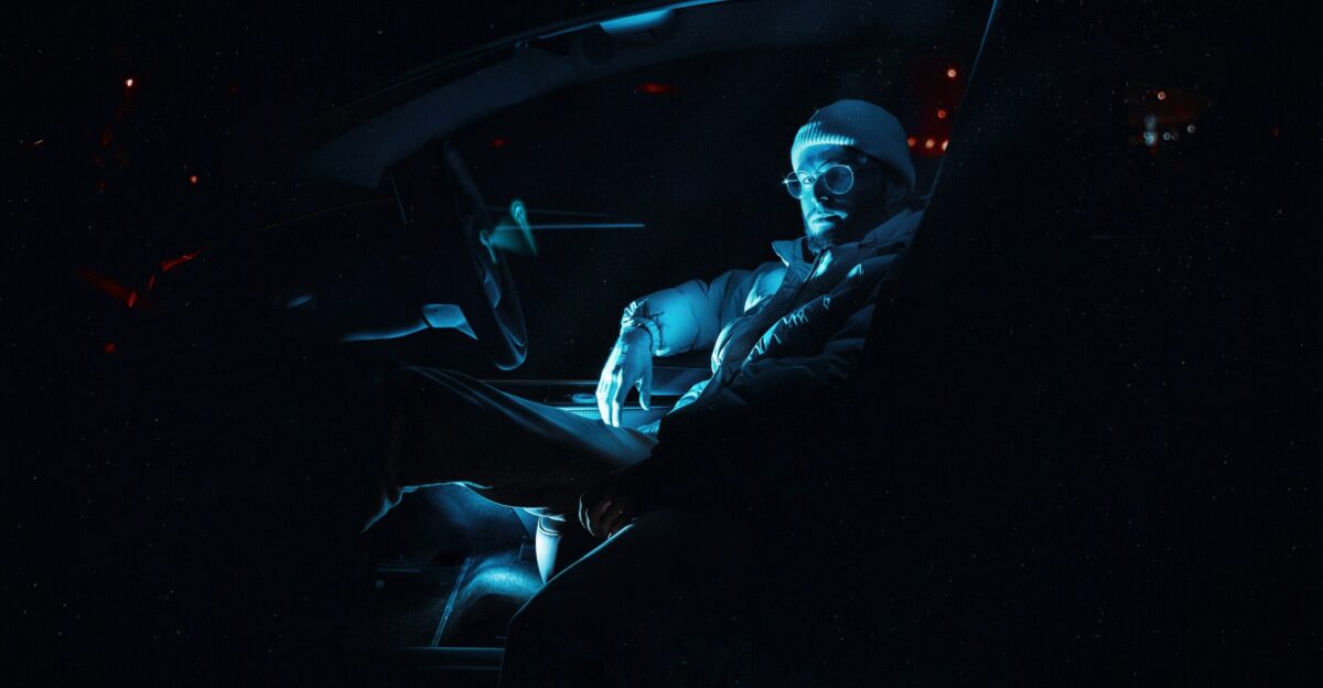 a man sitting in a car in the dark