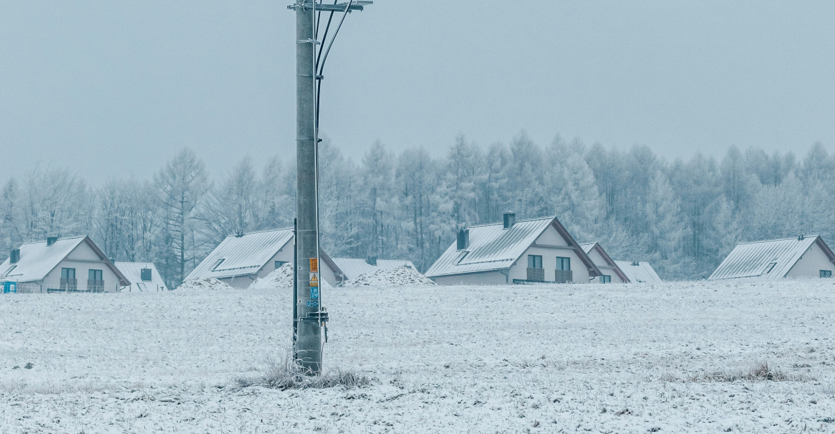 a telephone pole in the middle of a snowy field