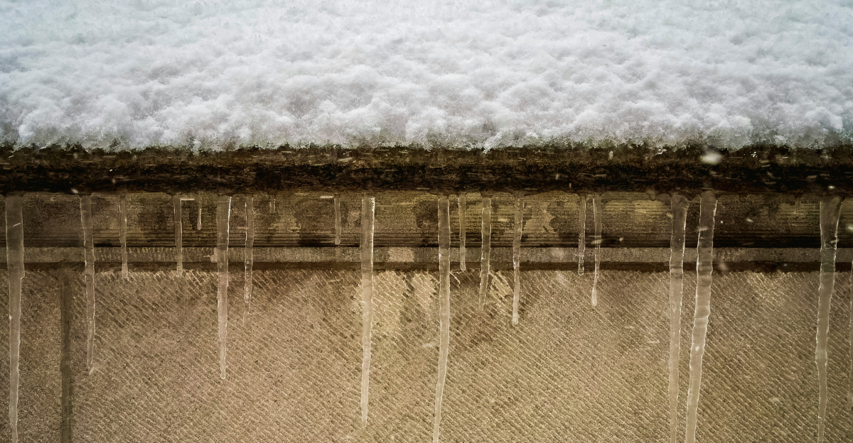 a snow covered roof with icicles hanging off of it