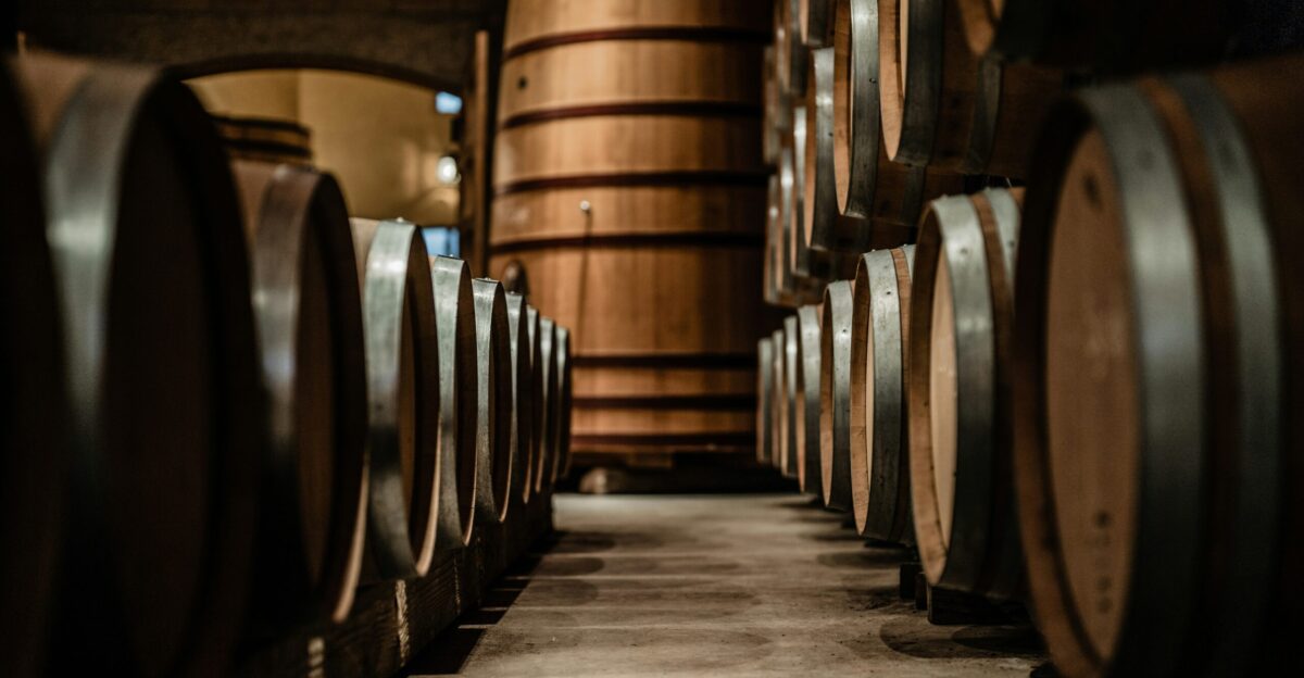 a row of wine barrels in a wine cellar