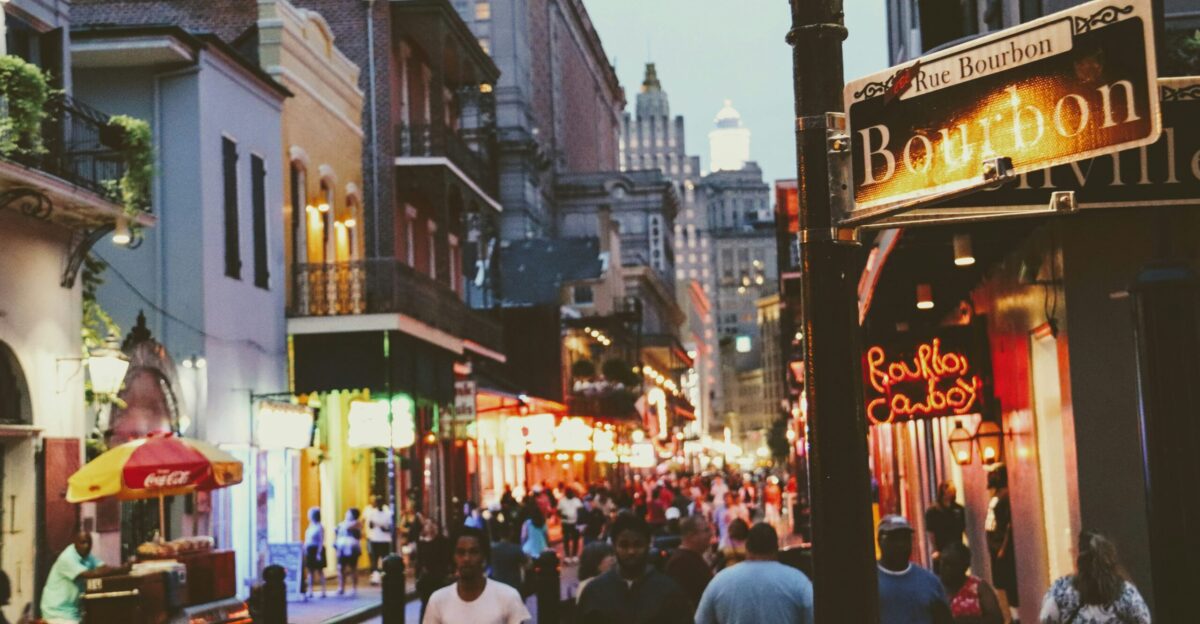 a group of people walking down a street next to tall buildings