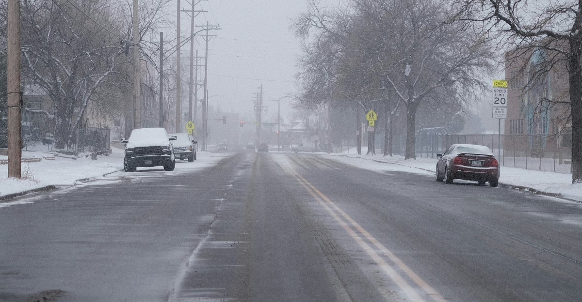a car driving down a snow covered street
