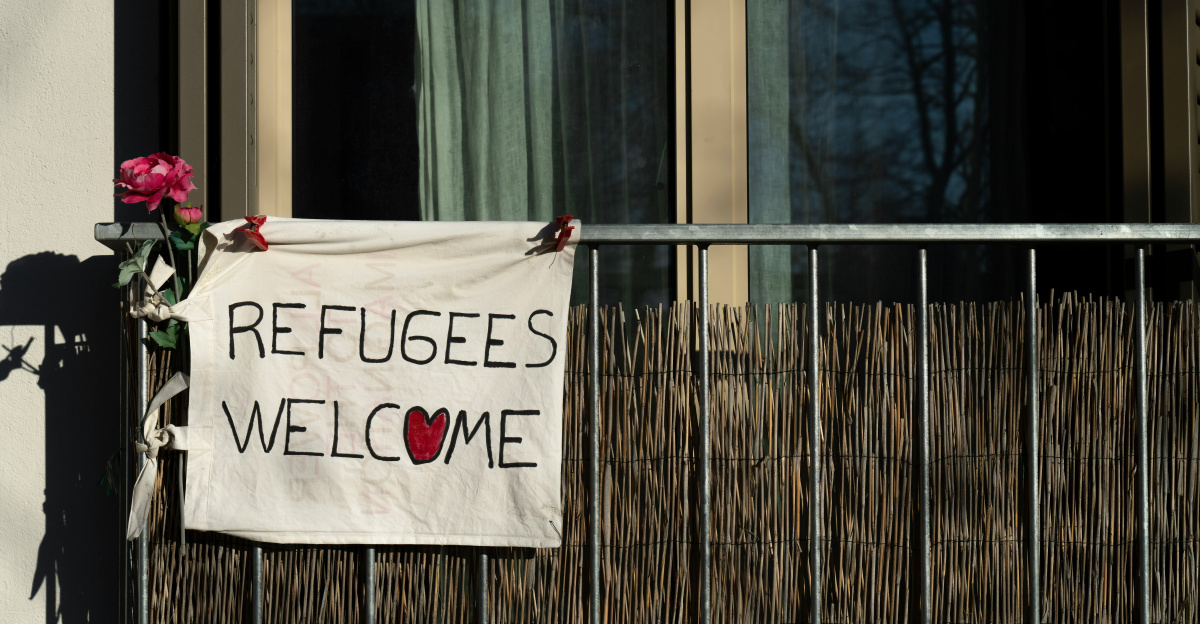 a sign that says refugees welcome on a building