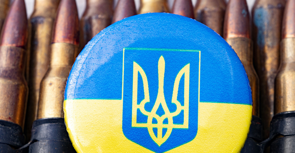 a blue and yellow button sitting on top of a bunch of bullet shells