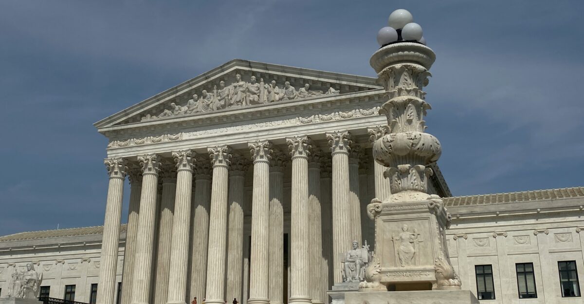 a large building with columns and a clock on top of it