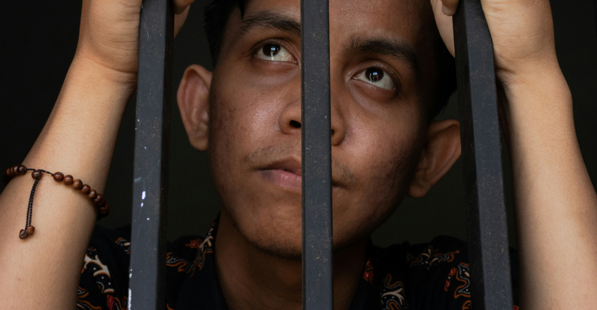 a man is looking out of a jail cell