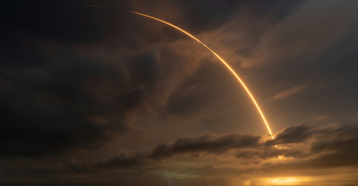 a large jet flying through a cloudy sky