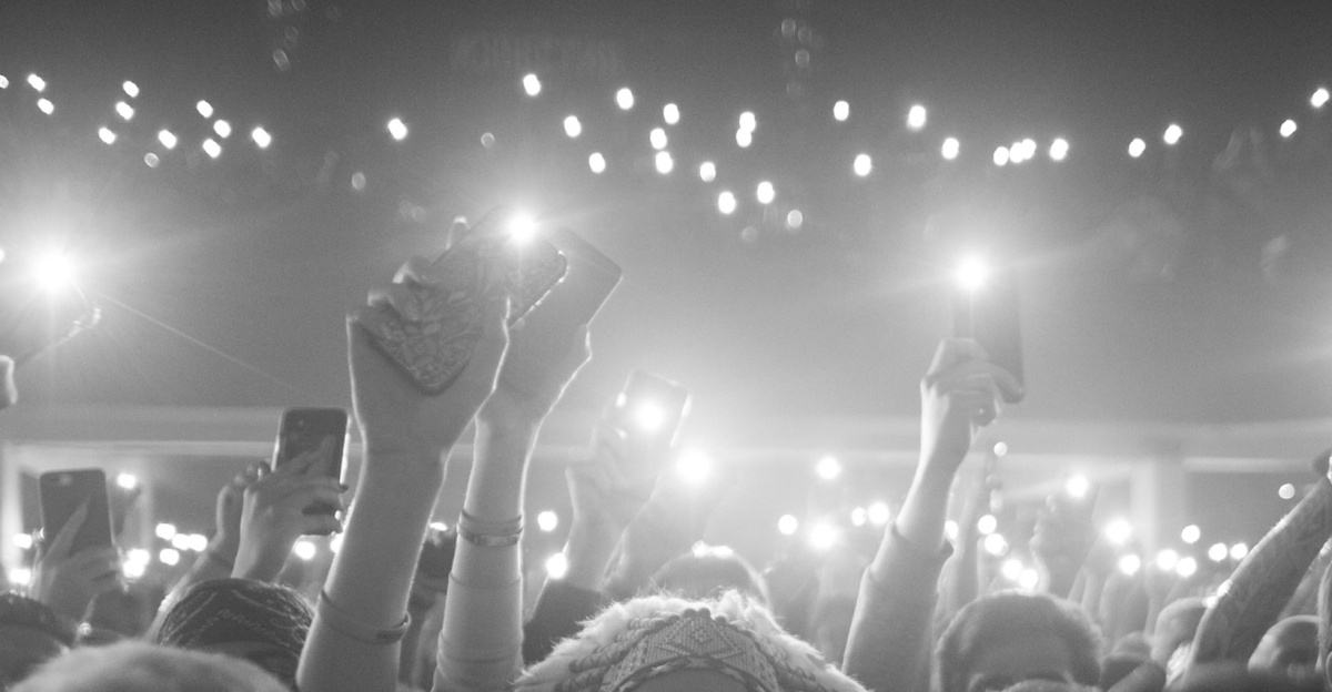 a crowd of people holding up their cell phones