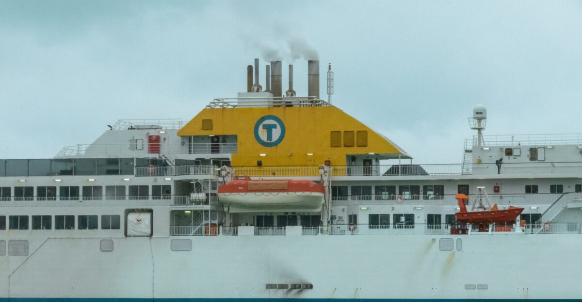 a large white ship with a yellow and green sign on it s side