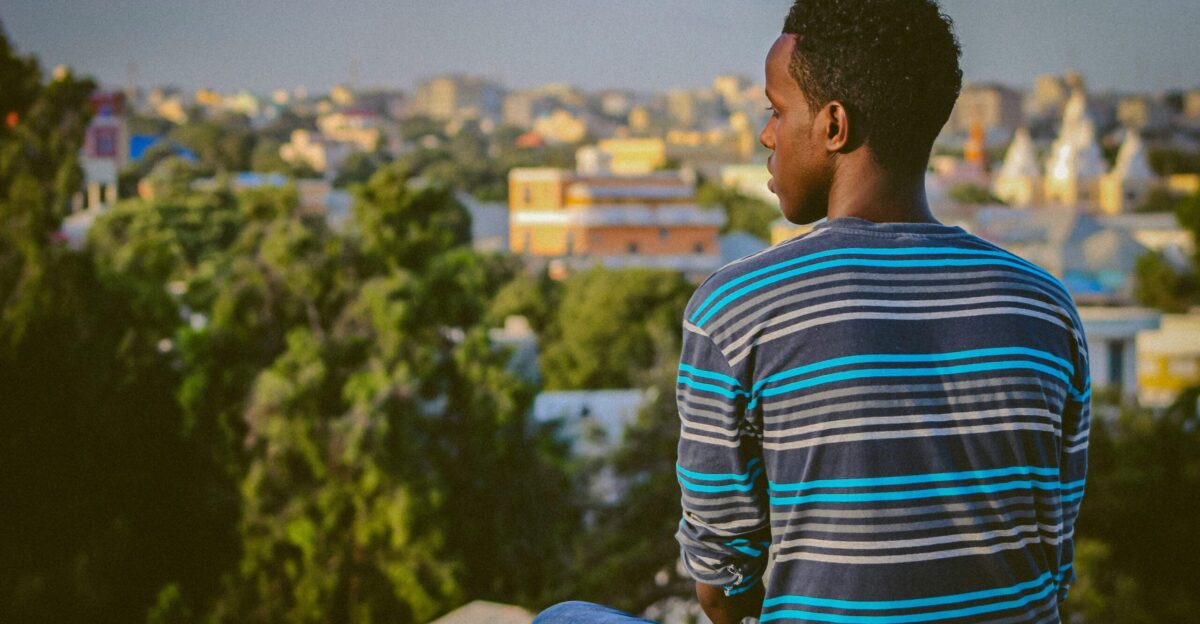 a man sitting on a ledge overlooking a city