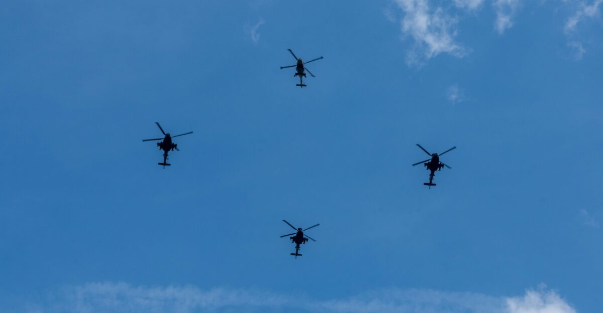 a group of four airplanes flying through a blue sky