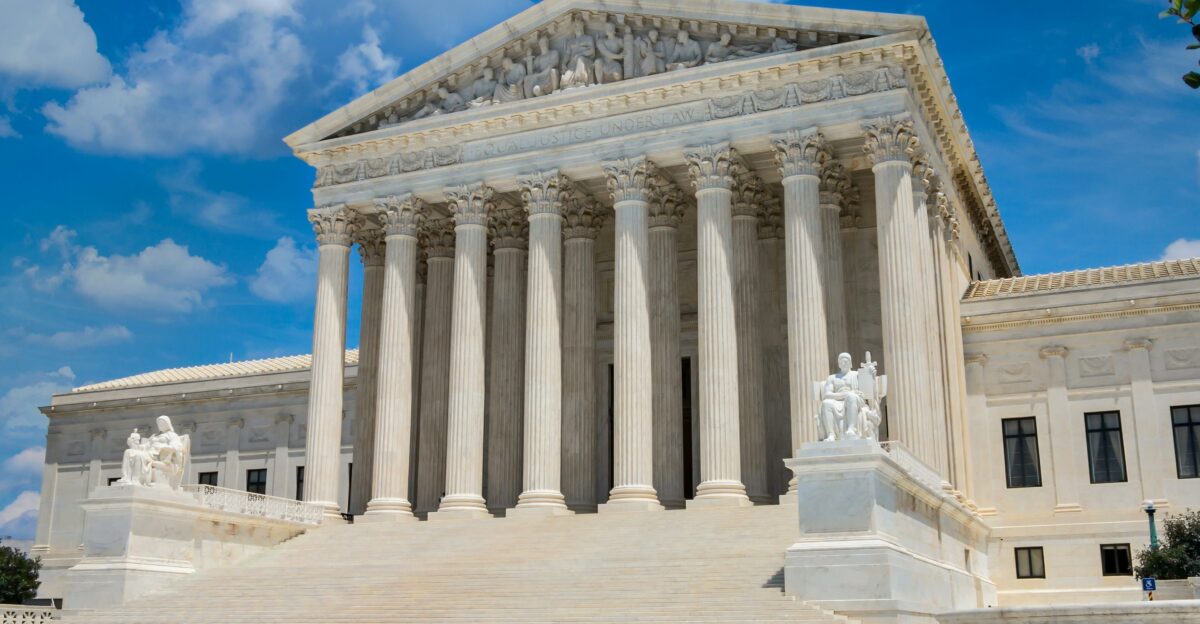 a large white building with columns with United States Supreme Court Building in the background
