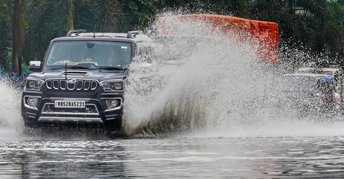 a car driving down a street next to water