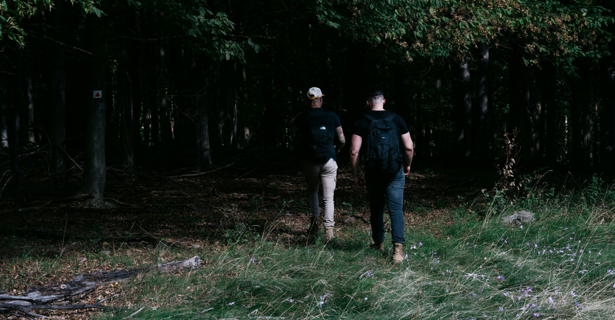 two people standing in a forest