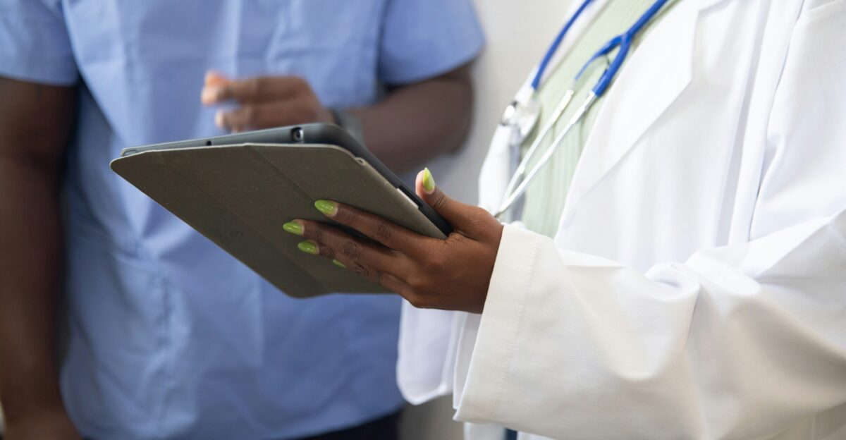 a doctor showing a patient something on the tablet