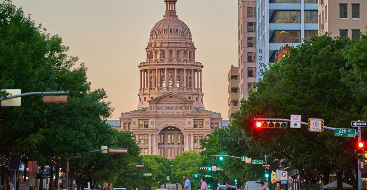 a large building towers over Texas State Capitol