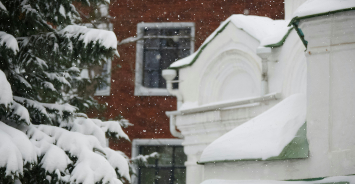 a red fire hydrant covered in snow in front of a red brick building