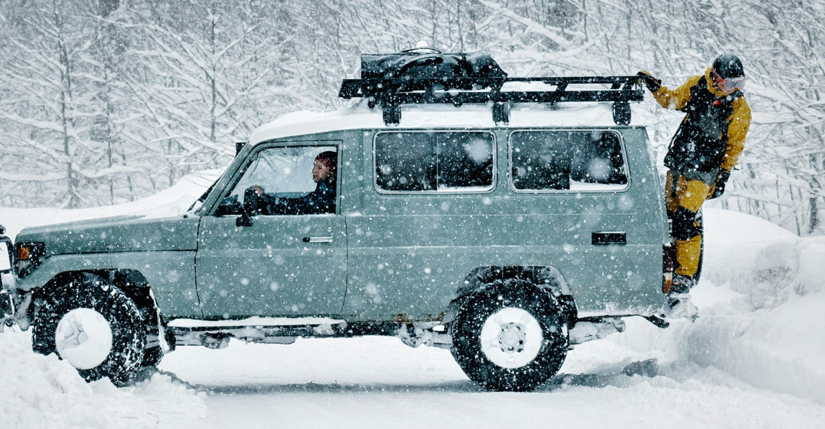 a man standing on top of a truck in the snow