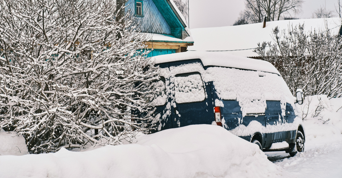 a car is covered in snow in front of a house