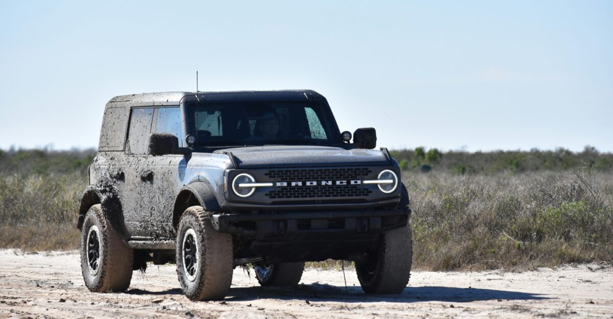 a black truck parked on a dirt road