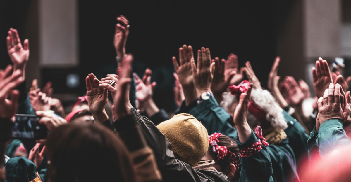 a large group of people with their hands in the air