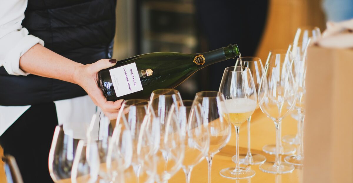 a person pouring wine into a wine glass