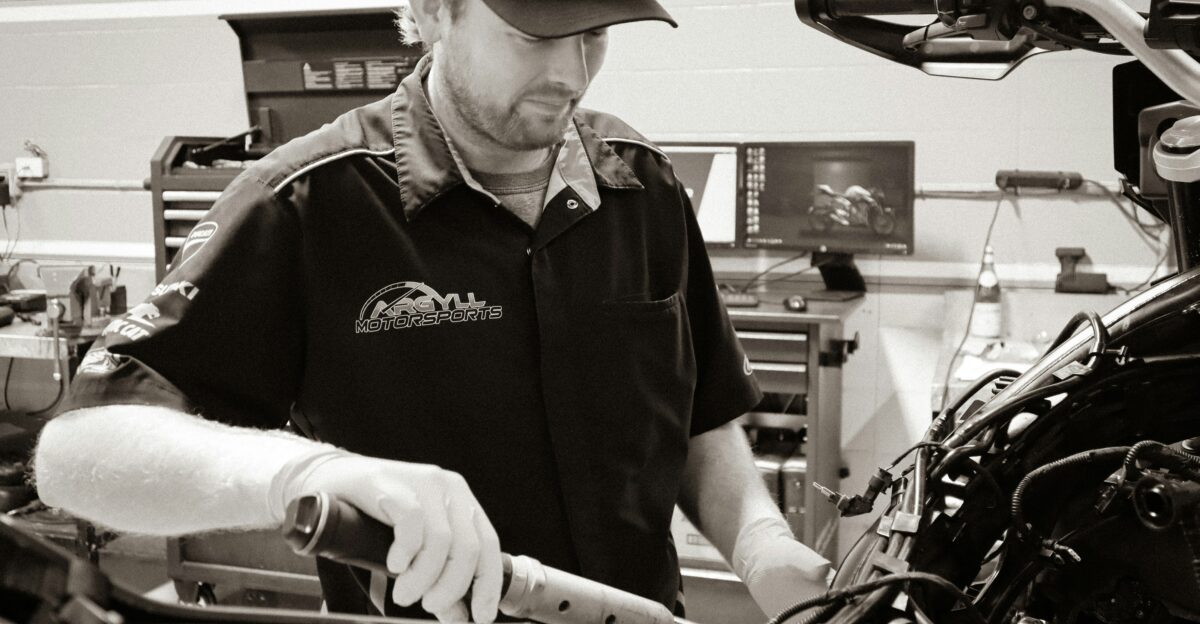 a man working on a motorcycle in a garage