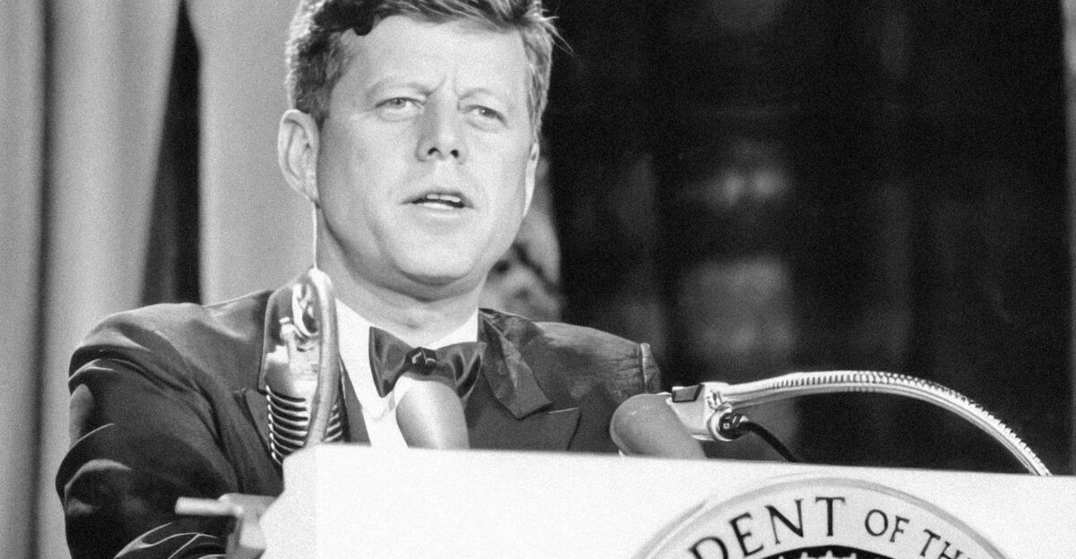 a man in a suit and tie standing at a podium
