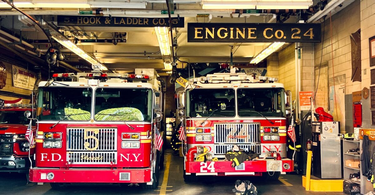 two fire trucks parked inside of a fire station