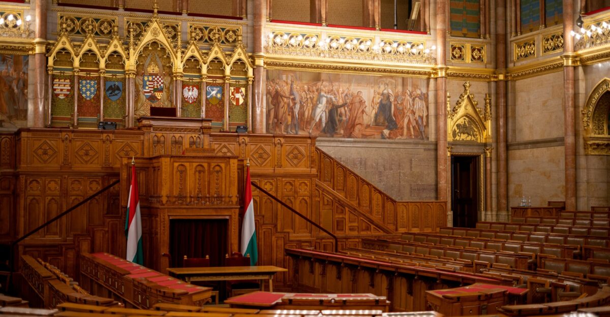 the interior of a large building with wooden pews