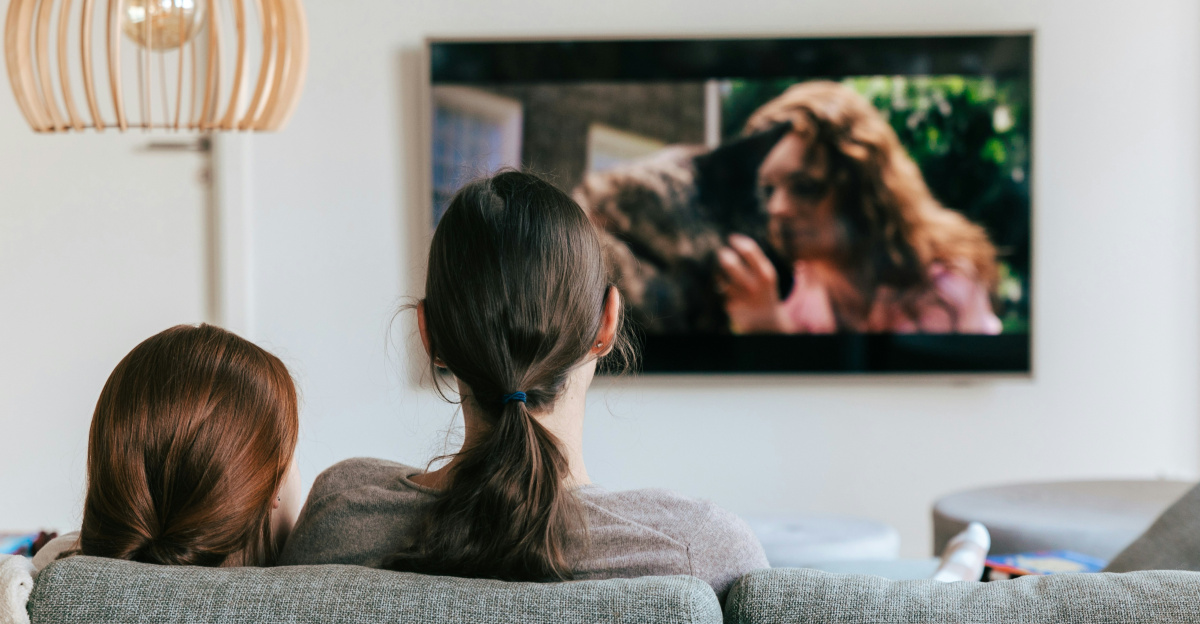 a couple of women sitting on top of a couch
