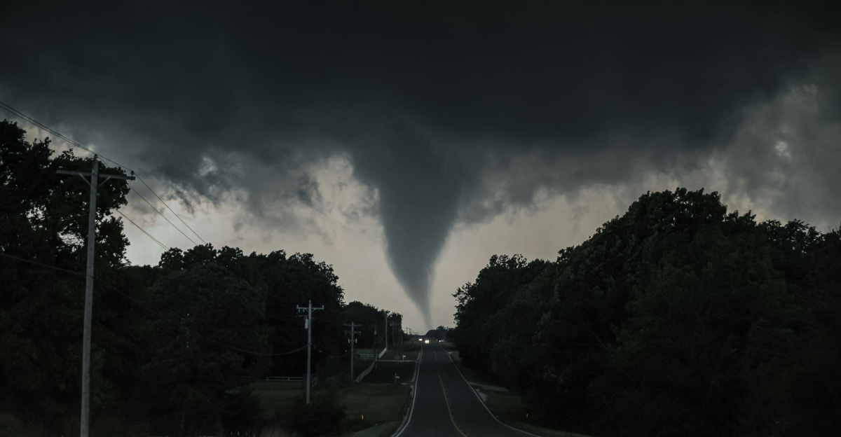 a large tornado is seen in the sky over a road