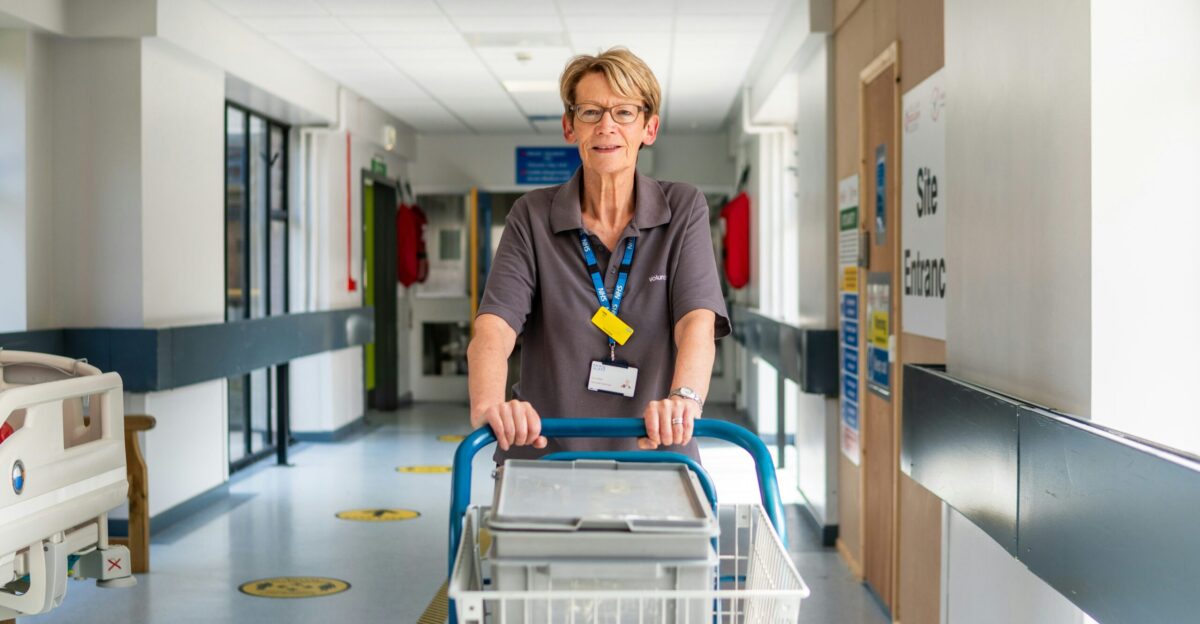 a woman pushing a shopping cart down a hallway
