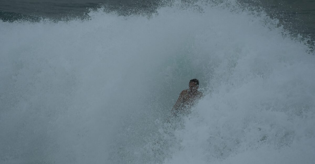 a man riding a wave on top of a surfboard
