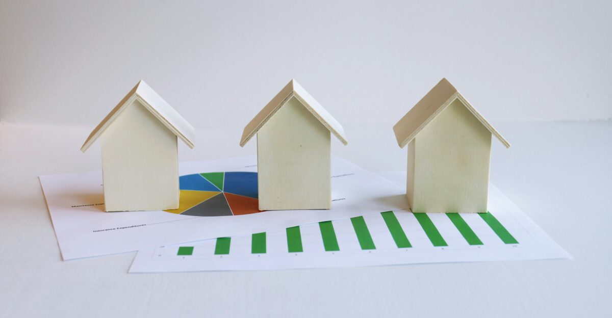 three small houses sitting on top of a piece of paper