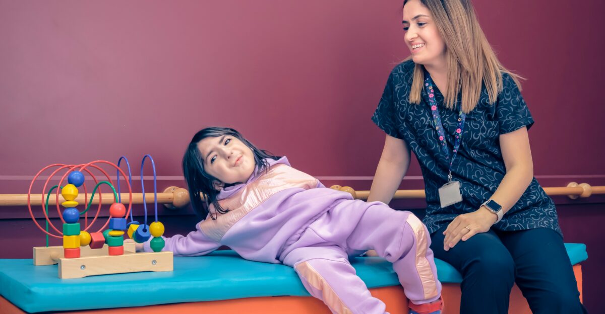 a woman sitting next to a little girl on a bench