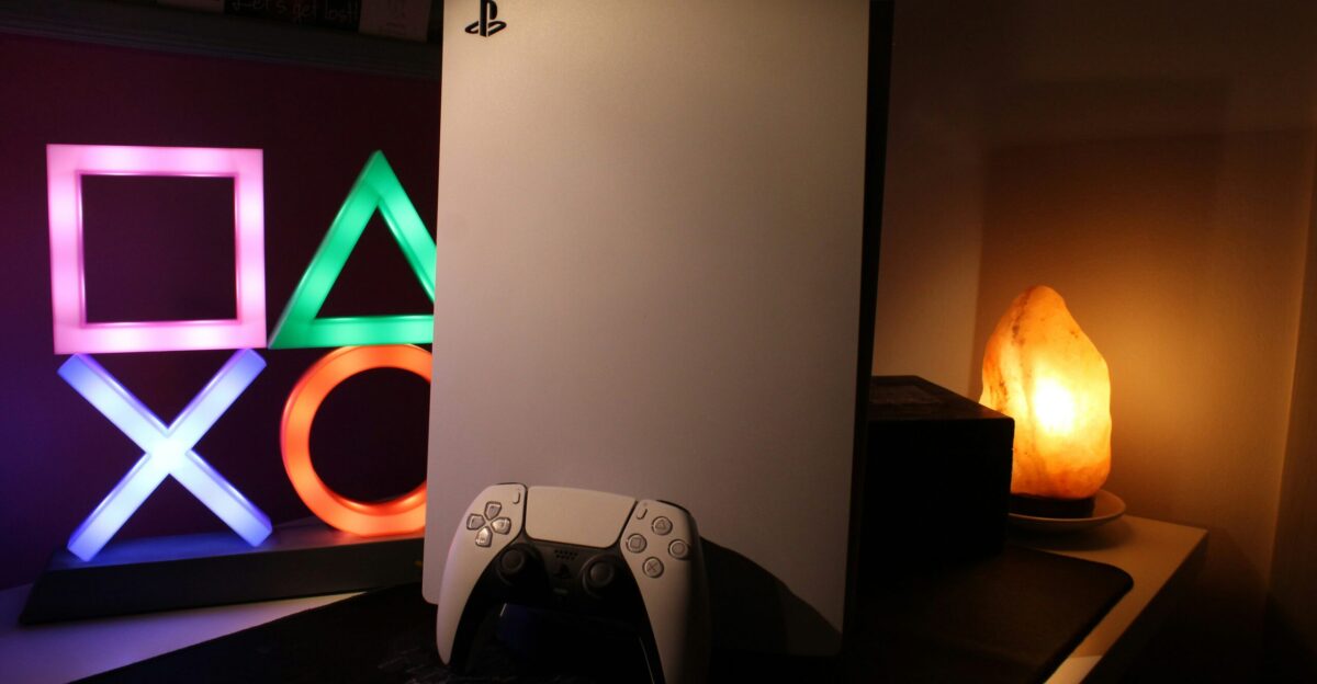 a video game console next to a neon sign